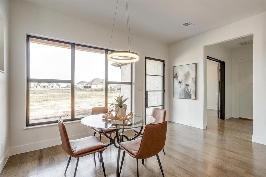 Dining space featuring baseboards, visible vents, and wood finished floors