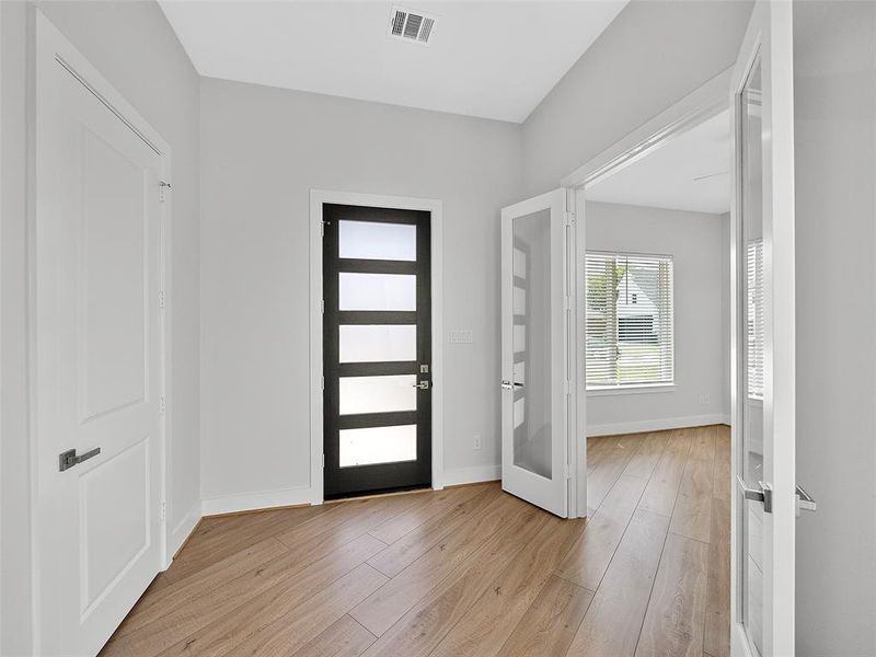 Entryway with light hardwood / wood-style flooring and french doors