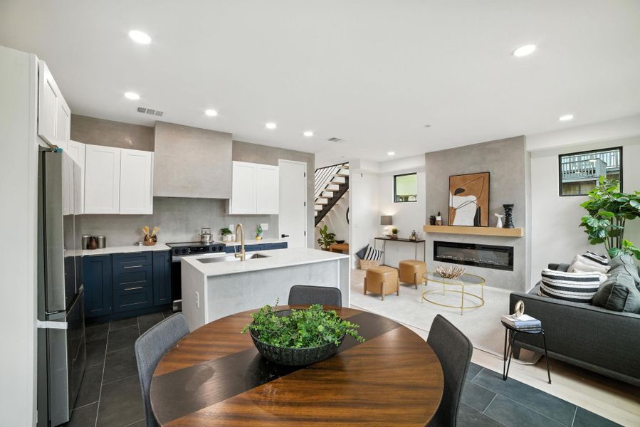 Dining area featuring stairs, a glass covered fireplace, dark tile patterned flooring, and recessed lighting Dining area featuring stairs, a glass covered fireplace, dark tile patterned flooring, and recessed lighting