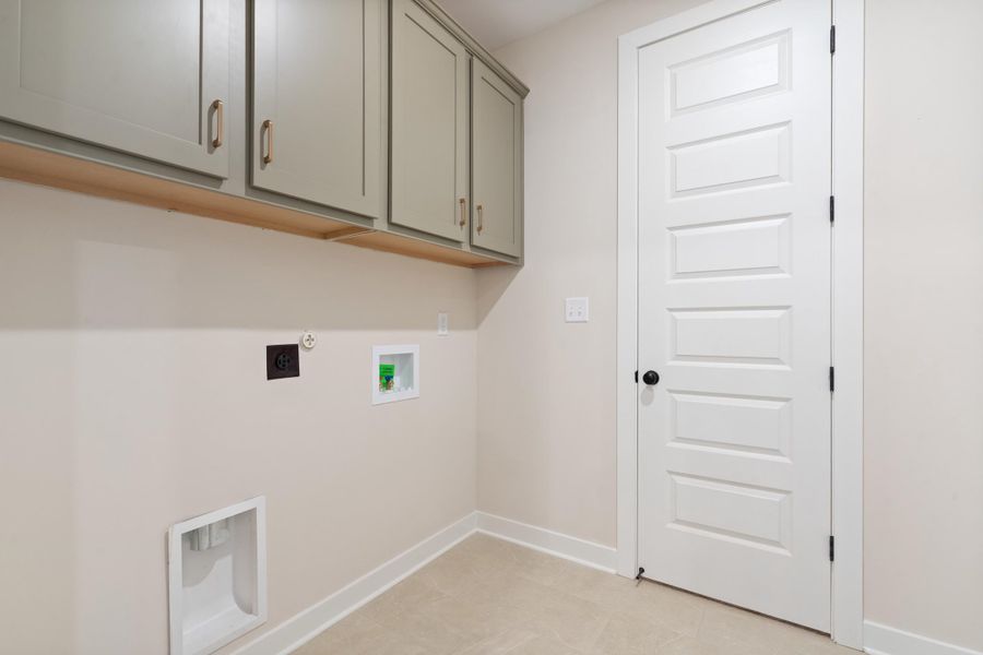 Wall-mounted cabinetry with wood shelving, paneled interior door, and light-toned flooring Wall-mounted cabinetry with wood shelving, paneled interior door, and light-toned flooring