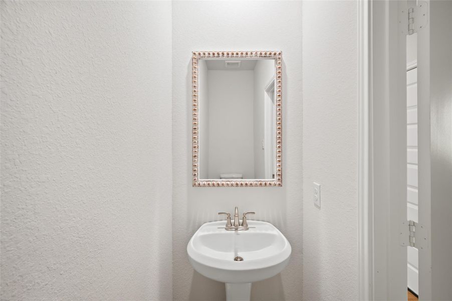 Convenient powder room with pedestal sink and stylish fixtures.