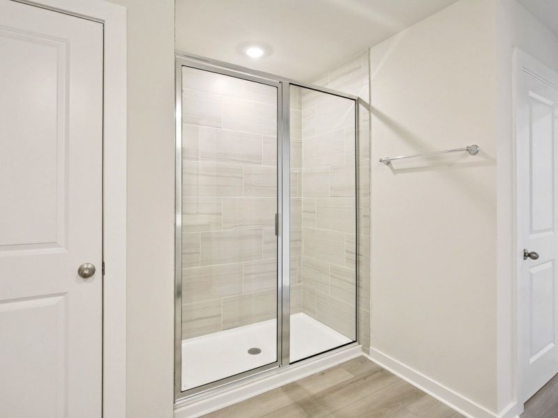 The primary bathroom offers dual vanity sinks and a walk-in shower.