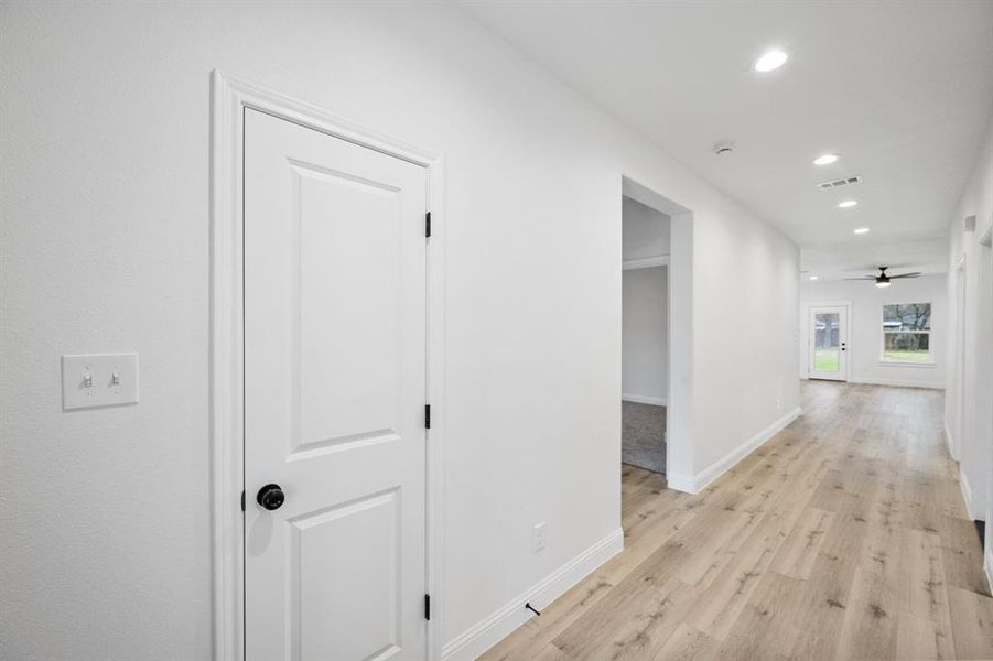 Hall featuring baseboards, recessed lighting, visible vents, and light wood-style floors