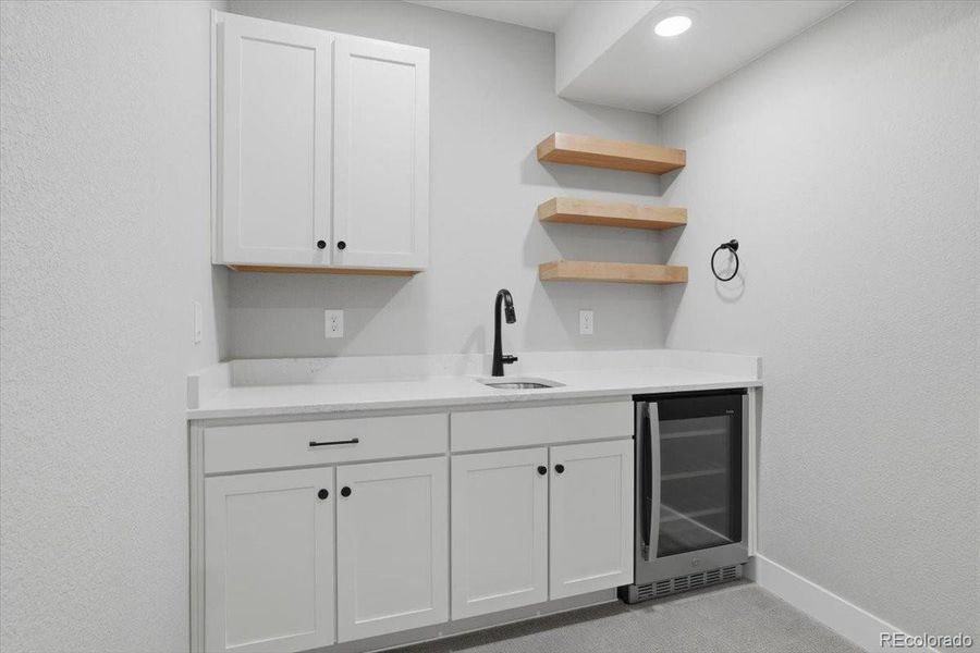 The family room has a built-in wet bar with lots of storage, a wine fridge and open shelving.