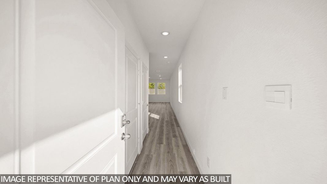 Entryway featuring wood-finish flooring, recessed lighting, white walls, and a white paneled door with polished hardware