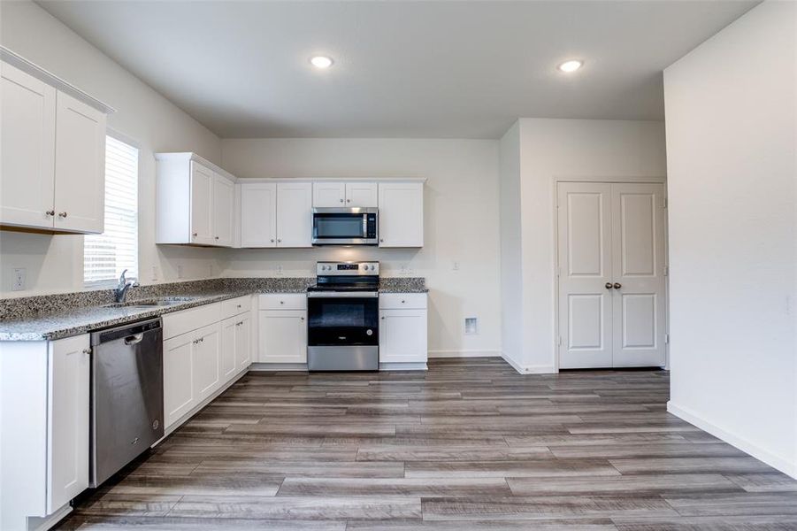 Kitchen featuring sink, white cabinets, and appliances with stainless steel finishes