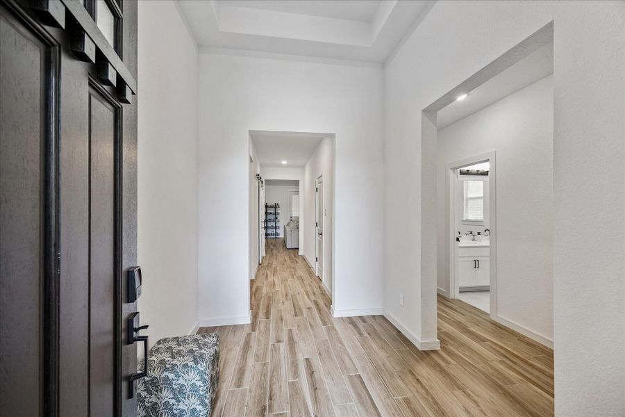 Spacious gallery-style foyer offering clean architectural lines, elevated ceiling detail, and an open sightline that draws you into the main living spaces.