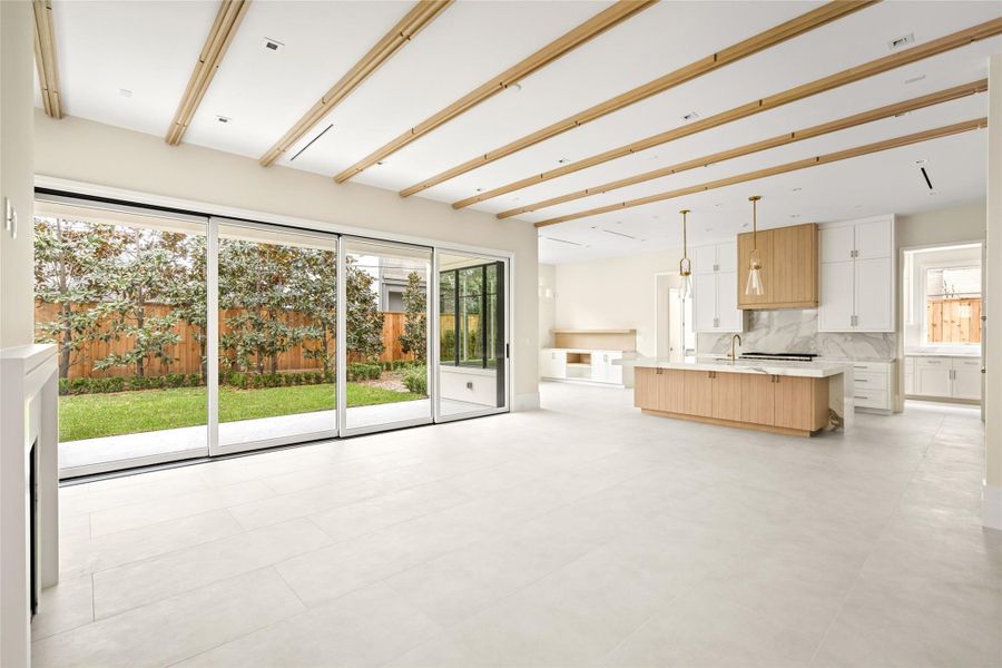 An airy, light-filled layout brings together the family room and kitchen in one cohesive, inviting space.