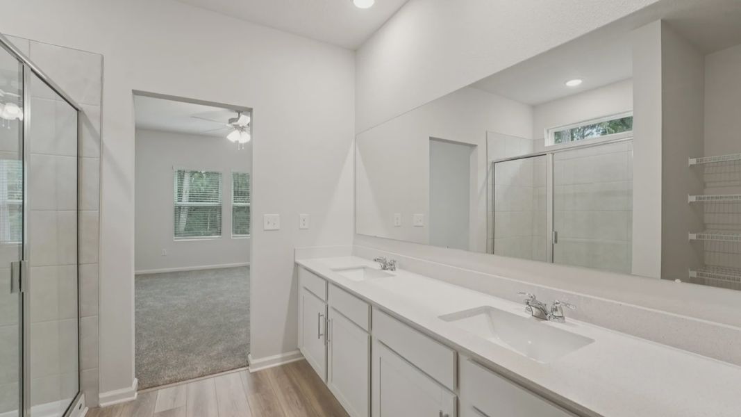 Exquisite dual vanity, quartz counters, and elegant tiled shower enhance this serene Palm Coast retreat.