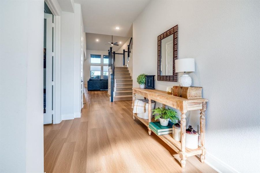 Hall featuring light wood-style floors, stairway, and recessed lighting