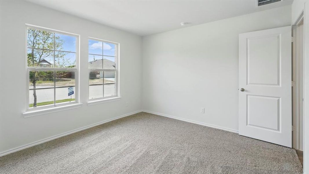 Carpeted spare room featuring baseboards