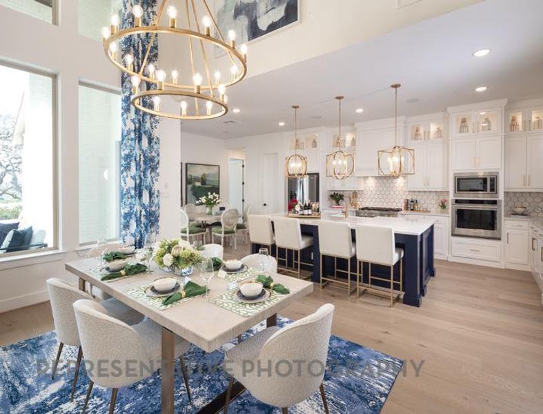 Dining area with a high ceiling, a notable chandelier, light wood-type flooring, and recessed lighting Dining area with a high ceiling, a notable chandelier, light wood-type flooring, and recessed lighting