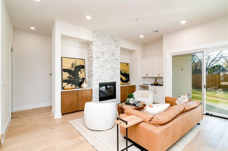 Living room featuring light hardwood / wood-style floors and a stone fireplace