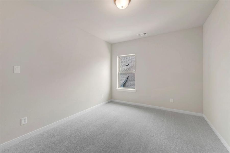 Empty room with light colored carpet and baseboards