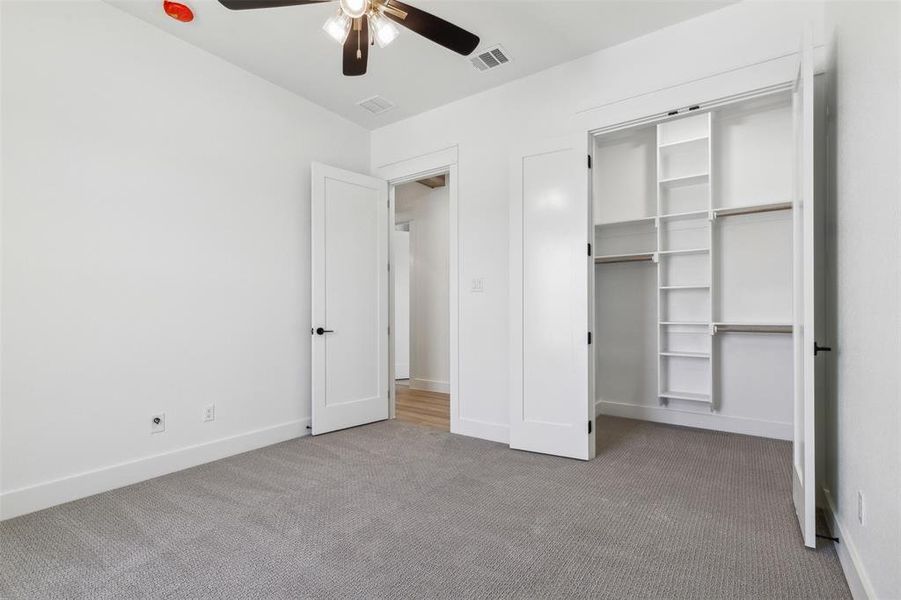 Unfurnished bedroom featuring a closet, carpet floors, and ceiling fan