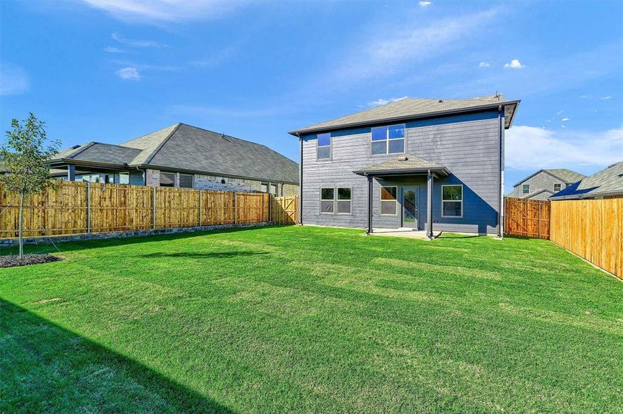 Back of property featuring a yard and a patio