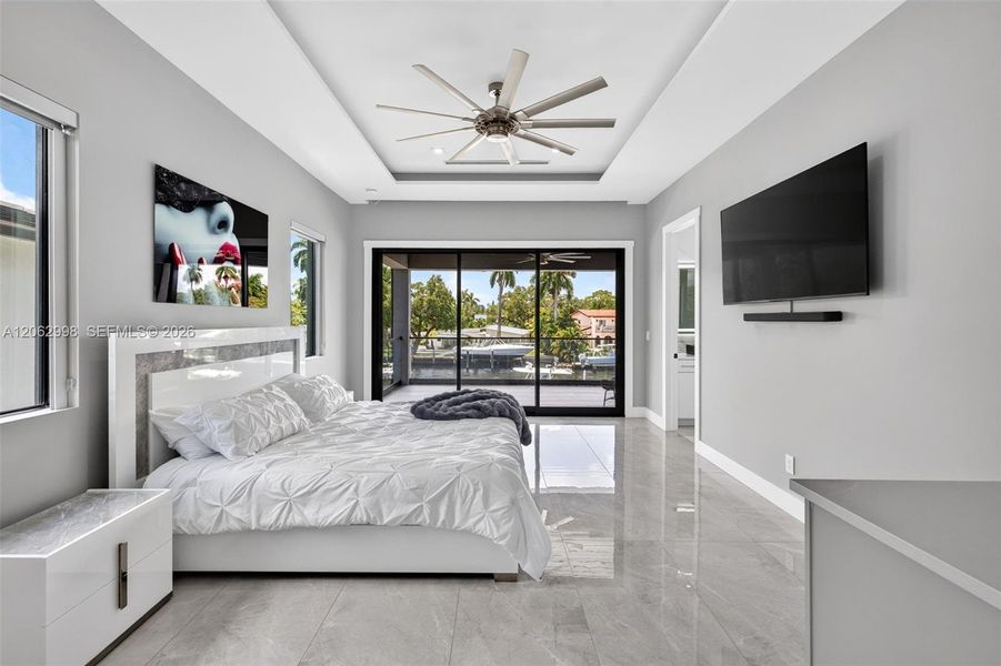 Primary bedroom suite w/ french doors, morning bar, en suite walk in closet and spa bathroom. Sliders lead to private balcony looking down the river