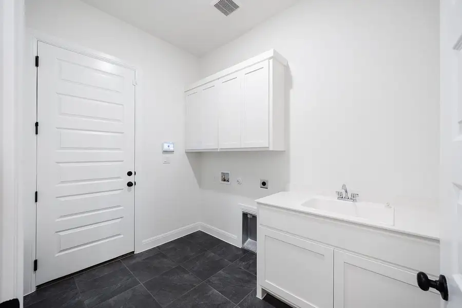 Laundry room with electric dryer hookup, hookup for a washing machine, cabinet space, and baseboards Laundry room with electric dryer hookup, hookup for a washing machine, cabinet space, and baseboards