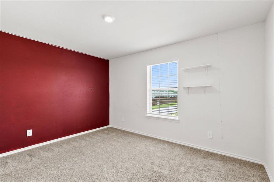 Bedroom featuring a vibrant accent wall, neutral carpeting, a single window with blinds, and recessed lighting