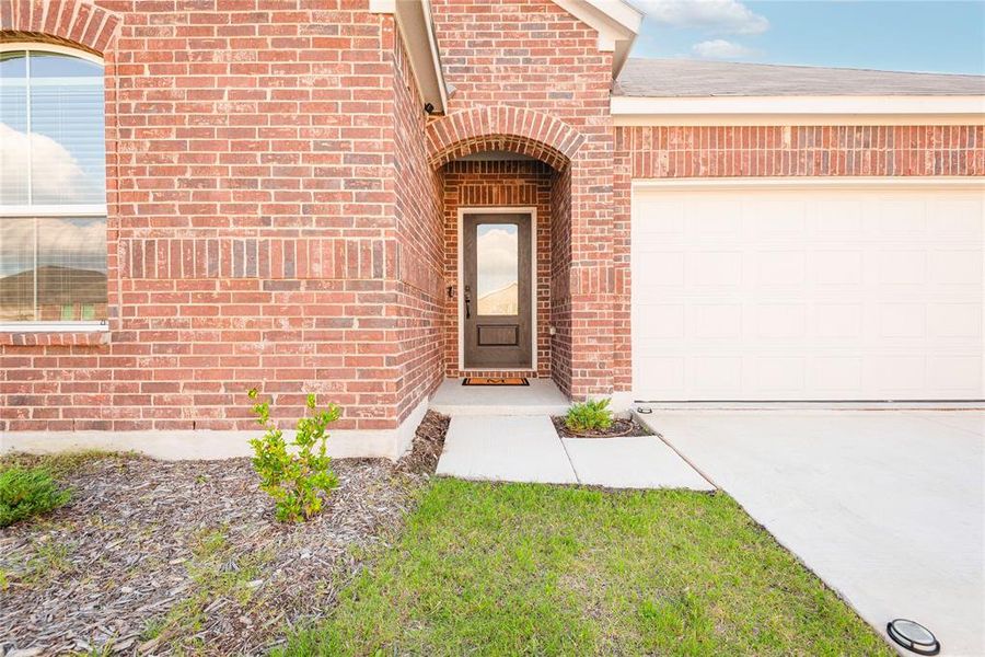 Brick exterior with an arched entryway and a dark-paneled front door Brick exterior with an arched entryway and a dark-paneled front door