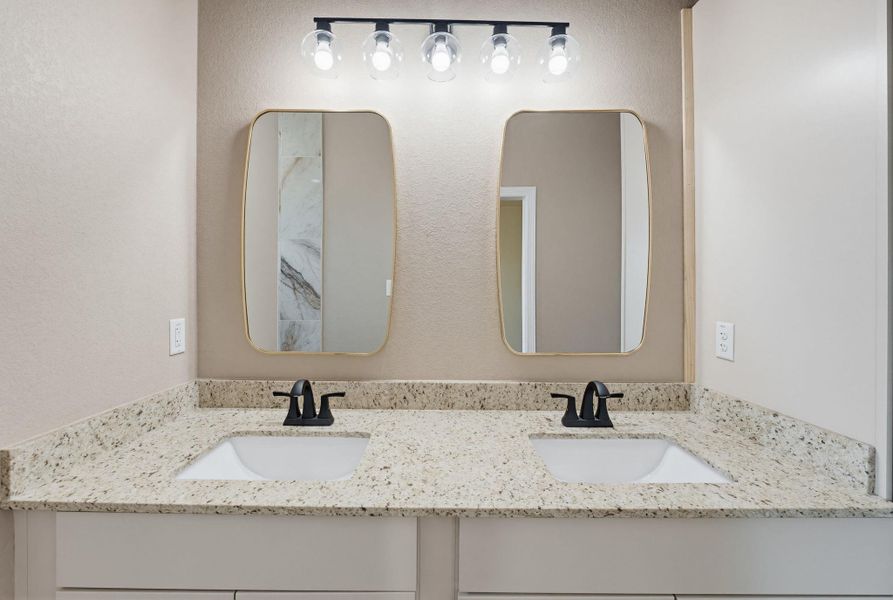 Bathroom with double vanity and a textured wall