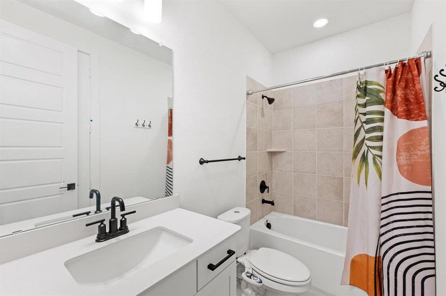 Bathroom featuring a white vanity with an integrated sink, matte black faucet, and a large wall-mounted mirror Bathroom featuring a white vanity with an integrated sink, matte black faucet, and a large wall-mounted mirror