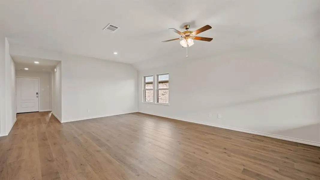 Spacious interior room featuring wood-finish flooring, recessed lighting, and a ceiling fan with light fixture Spacious interior room featuring wood-finish flooring, recessed lighting, and a ceiling fan with light fixture