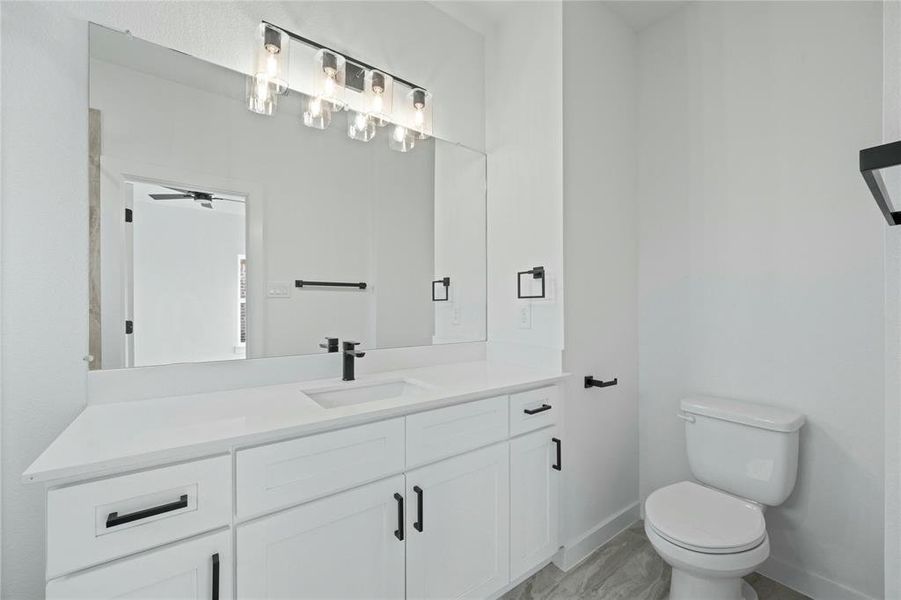 Bathroom with vanity, marble look tiles, and a ceiling fan Bathroom with vanity, marble look tiles, and a ceiling fan