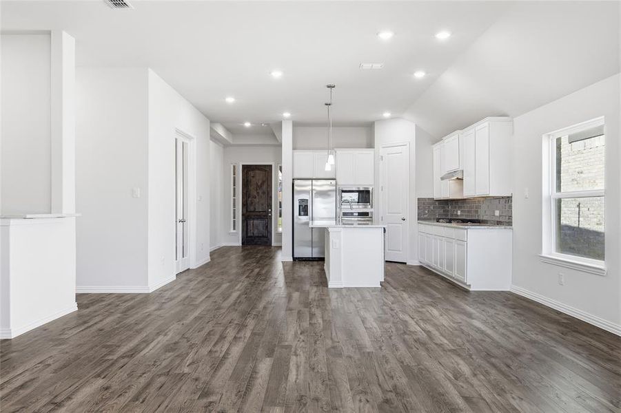 Open-concept living area featuring wood-finish flooring and recessed lighting
