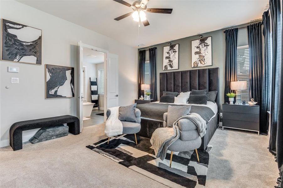 Bedroom featuring light carpet, a ceiling fan, and ensuite bath