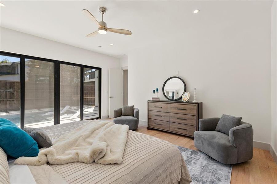 Bedroom featuring ceiling fan, light hardwood / wood-style flooring, access to exterior, and multiple windows