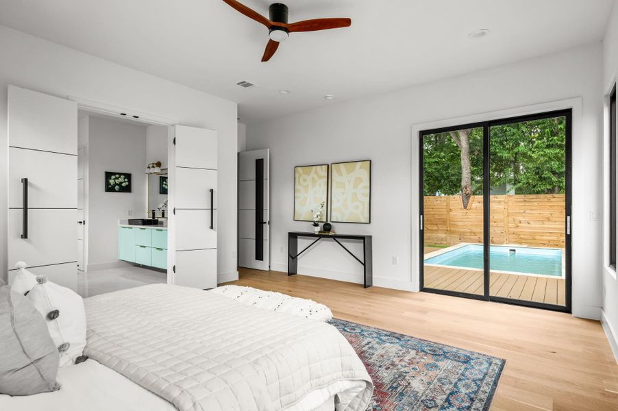 Hardwood flooring and clean white walls frame a private pool oasis just beyond sliding glass doors. Hardwood flooring and clean white walls frame a private pool oasis just beyond sliding glass doors.
