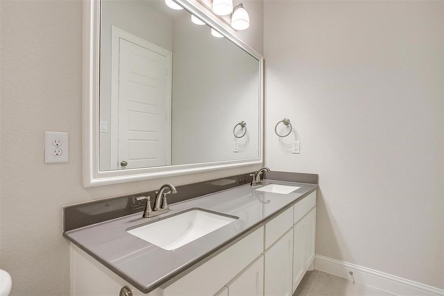 Bathroom with tile patterned flooring and dual bowl vanity