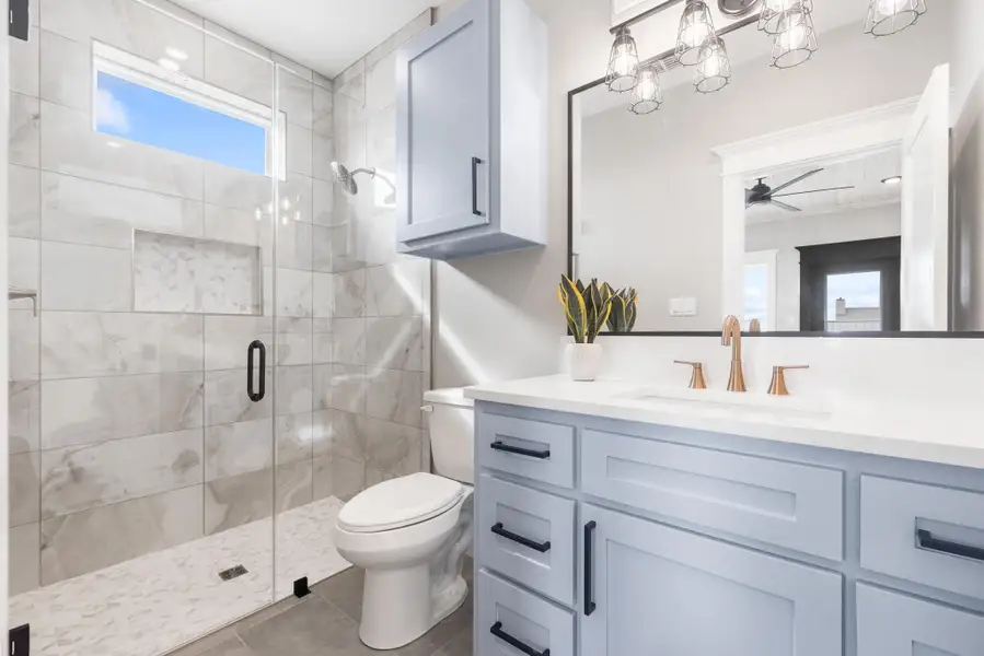 Full bathroom with vanity, a shower stall, ceiling fan, and tile patterned floors Full bathroom with vanity, a shower stall, ceiling fan, and tile patterned floors