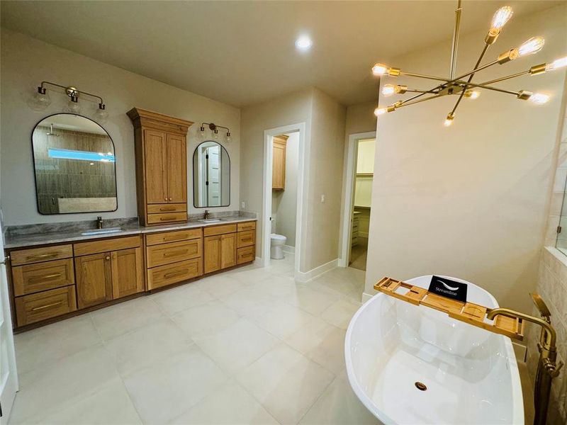 Full bathroom with an inviting chandelier, vanity, plus walk in shower, and toilet