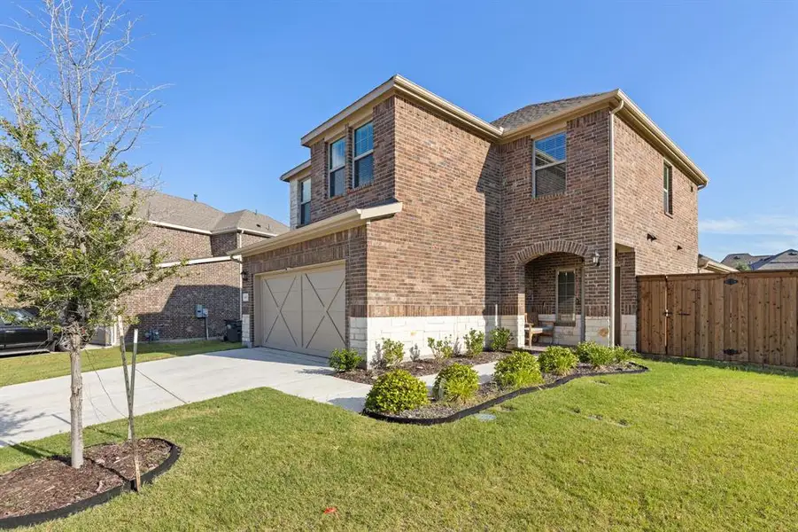 Front exterior of a new home in Spiritas Ranch, Little Elm, TX, highlighting curb appeal (Image 2). Front exterior of a new home in Spiritas Ranch, Little Elm, TX, highlighting curb appeal (Image 2).