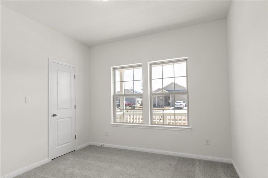 Empty room featuring baseboards and light colored carpet