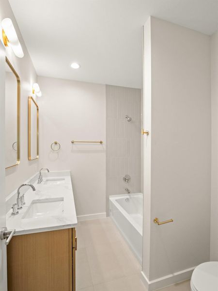 Contemporary bathroom featuring a dual vanity with a white countertop and wood-finish cabinetry