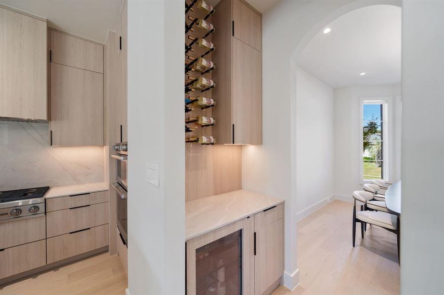 A wonderful bar off the kitchen and convenient to the living room offers a beverage fridge and wine storage, as well as additional storage cabinets for glasses, china and crystal stemware.