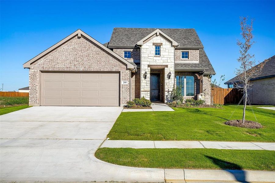 View of front of property featuring a front yard and a garage