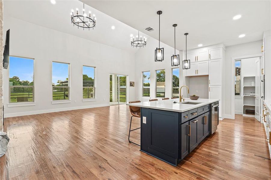 Kitchen featuring a chandelier, open floor plan, white cabinetry, light countertops, and recessed lighting Kitchen featuring a chandelier, open floor plan, white cabinetry, light countertops, and recessed lighting