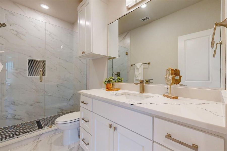 Hall Bathroom with tile flooring, oversized vanity, toilet, and walk in shower