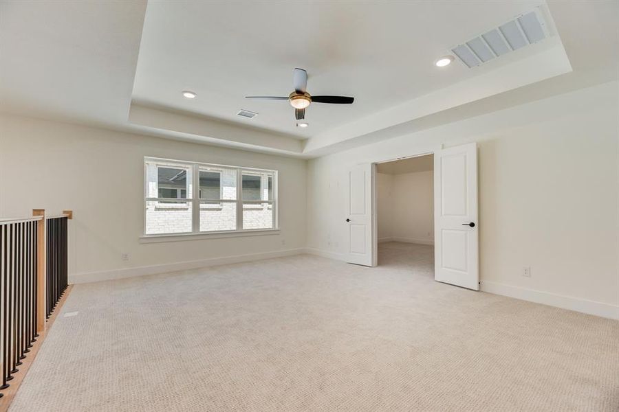 Unfurnished bedroom featuring a raised ceiling, light colored carpet, a ceiling fan, and recessed lighting Unfurnished bedroom featuring a raised ceiling, light colored carpet, a ceiling fan, and recessed lighting