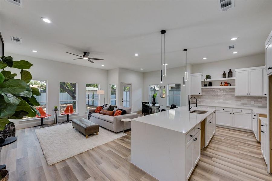 Kitchen featuring white cabinetry and an island with sink