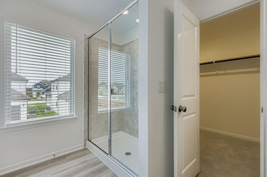 Bathroom featuring a walk in closet, a stall shower, light wood-type flooring, and recessed lighting Bathroom featuring a walk in closet, a stall shower, light wood-type flooring, and recessed lighting