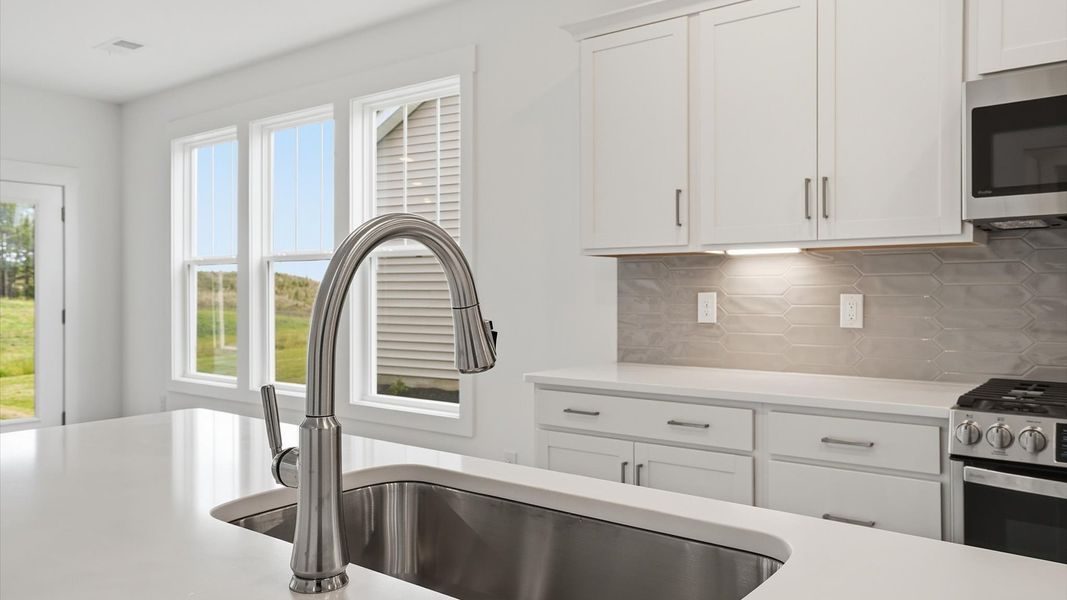 Accomplished kitchen design featuring pendant lighting above a statement island for both prep and gathering