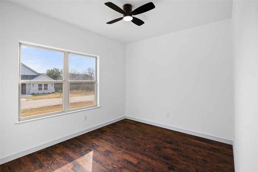 Spare room with dark wood finished floors and ceiling fan