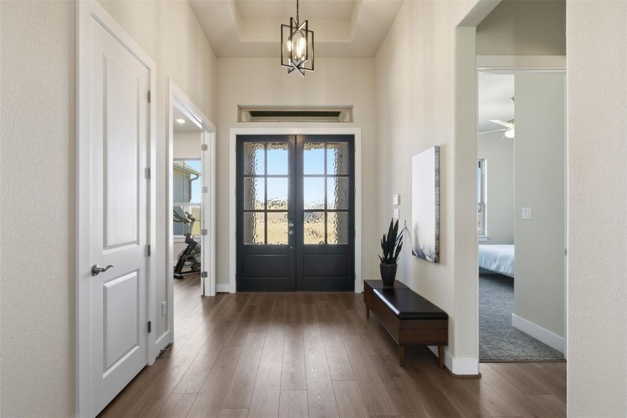 Entrance foyer with hardwood / wood-style floors, suspended lighting, a ceiling fan, and french doors