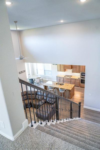 Stairway with wood finished floors and recessed lighting