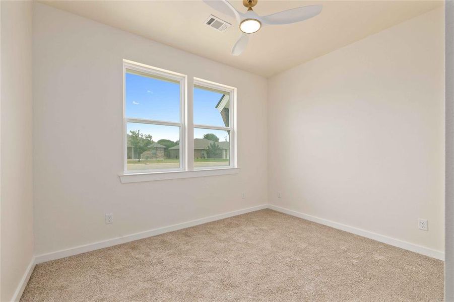 Spare room featuring light carpet and a ceiling fan Spare room featuring light carpet and a ceiling fan